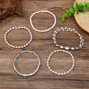 Set de bracelets bohèmes en perles turquoise et joncs en métal sur fond en bois