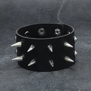Gros plan sur bracelet en cuir punk avec double rangée de clous coniques argentés