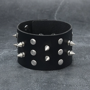 Bracelet punk large en cuir noir avec pointes et clous argentés sur fond de pierre grise