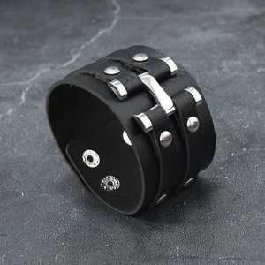 Punk black leather wide bracelet with silver metal rivets on dark marble background