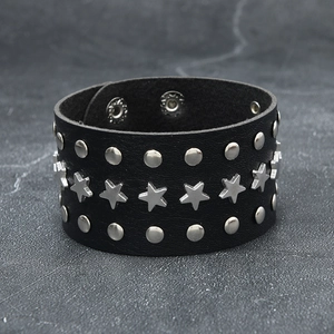 Punk rock black leather wristband with silver star rivets and snap buttons on stone