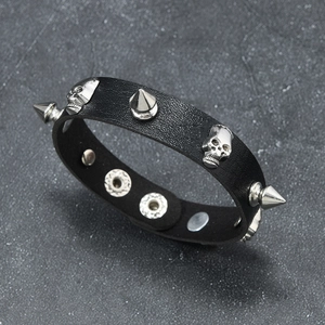 Bracelet punk en cuir noir avec têtes de mort argentées et clous sur pierre sombre