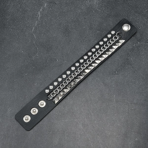 Detail view of multi-layer punk leather bracelet with silver studs and chain decoration