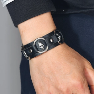 Punk style black leather bracelet with silver skull charms and metal rings for men and women