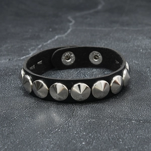 Punk style black faux leather bracelet with silver conical metal spikes and snap closure