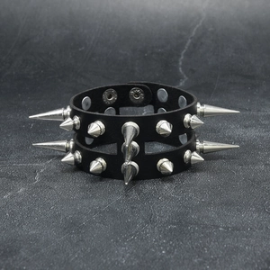 Dettaglio macro del bracciale in pelle gotico con borchie metalliche a doppia fila e bottoni