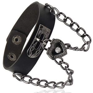 Detail of gothic heart lock with engraved patterns on black leather punk choker