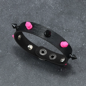 Close-up of punk leather bracelet with pink and black spikes and metal snap fasteners