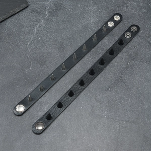 Detail view of black leather punk bracelets with silver and matte black metal spikes