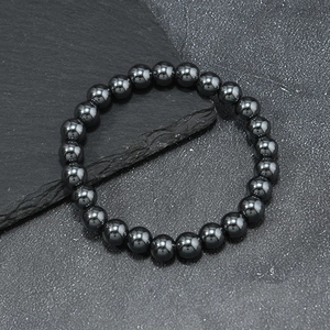 Polished tiger eye and hematite beaded bracelet on a natural stone background