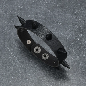 Detail of punk leather bracelet with black conical rivets and adjustable silver snaps