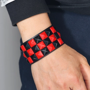 Punk wide black leather bracelet with three rows of red and black pyramid studs