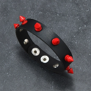 Detail view of black leather punk bracelet with red spikes and silver metal snap buttons