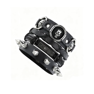 Détail d'un ensemble de bracelets punk en cuir noir avec têtes de mort et pointes en métal