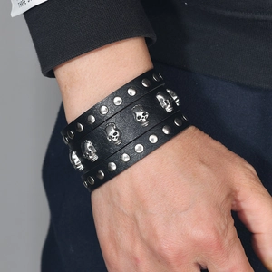 Punk vintage wide genuine leather bracelet with silver skull charms and studs on wrist