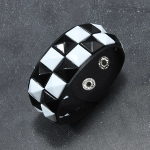 Detail of punk rivet bracelet with black and white pyramid studs and snap closure