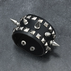 Détail du bracelet punk en cuir large avec clous carrés et pointes argentées