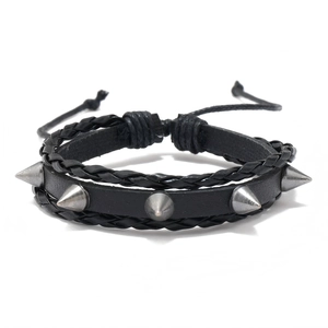 Black leather punk bracelet with silver metal spikes and woven ropes on white background