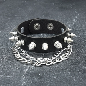 Detailansicht eines Punk-Lederarmbands mit silbernen Nieten und hängenden Ketten