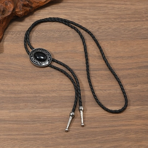Vintage western bolo tie with black leather cord and engraved silver metal buckle