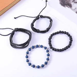 Detail of vintage multilayer braided leather and beaded bracelet set on artistic background