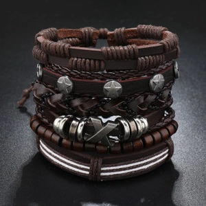 Detailed macro view of woven brown leather bracelets with metal star and X slider buckle