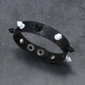 Detail of punk leather bracelet with black and white spikes and metal snap buttons