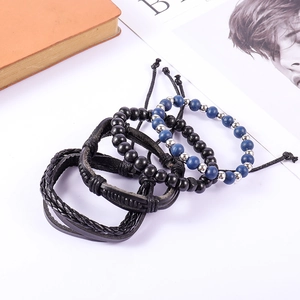 Flat lay of vintage multi-layer beaded and braided leather bracelet set on a magazine