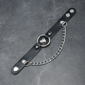 Close-up of punk black leather bracelet with silver heart pendant and metal ring detail