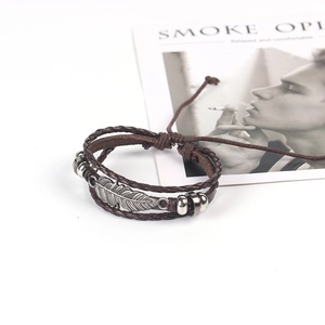 Vintage multilayer leather bracelet featuring metallic feather pendant and wooden beads