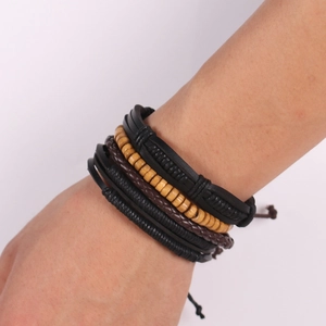 Close-up of multilayer leather bracelet set with brown braided cords and wooden beads