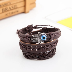 Detail of multi-layer leather bracelet with Hamsa Hand and Evil Eye metal charms