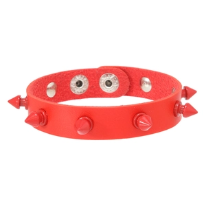 Detail of red punk leather bracelet featuring sharp studs and adjustable snap fastener