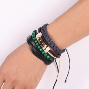 Détail d'un ensemble de bracelets bohèmes avec lanières en cuir et perles au poignet