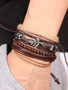 Macro detail of multi-layer bohemian bracelet with alloy maple leaf charm and wooden beads