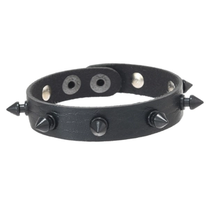 Macro shot of black leather punk bracelet featuring metallic cone spikes and snap closure