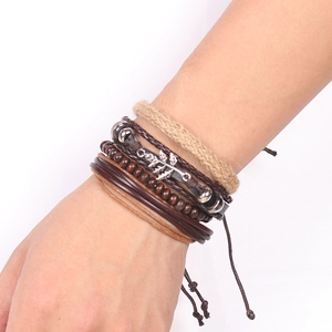 Close-up of multilayered leather bracelet with maple leaf charm and wooden beads