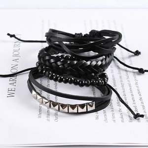 Detail of multi-layer punk bracelet set with black woven leather and silver metal studs