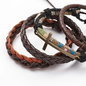 Vintage multi-layer braided leather bracelet set with bronze cross charm on white backdrop