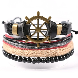 Détail d'un bracelet multicouche en cuir avec charm gouvernail en bronze et perles