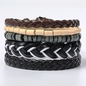 Close-up of retro braided leather bracelets and natural wooden beads set on white background