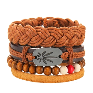 Detailed close-up of multilayer leather bracelets with wood beads and leaf charms