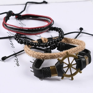 Lot de quatre bracelets vintage en cuir tressé avec breloques gouvernail en bronze
