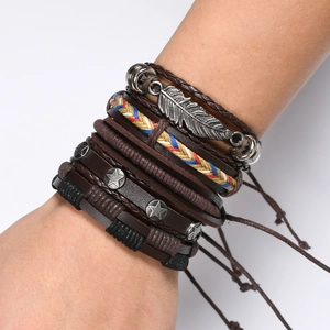 Close-up of multilayer braided leather bracelet with silver feather charm and star rivet
