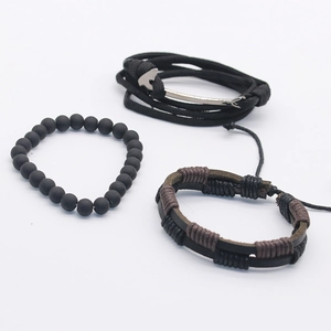 Close-up of a 3-piece set featuring a silver anchor hook and braided leather men's bracelets