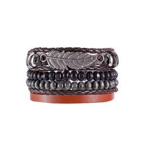 Detail view of multi-layer leather bracelet with silver feather charm and wooden beads