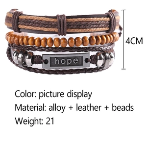 Detail of multi-layer leather bracelet featuring wood beads and antique hope letter plate