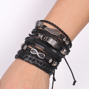 Men's multilayer leather bracelet set with wing and infinity charms on a white background