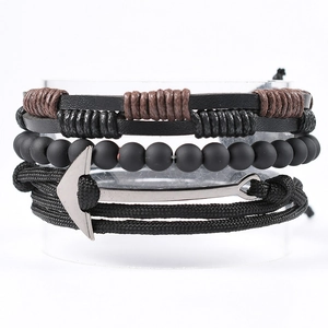 Detail view of multilayer leather bracelet featuring a silver metal anchor and black beads