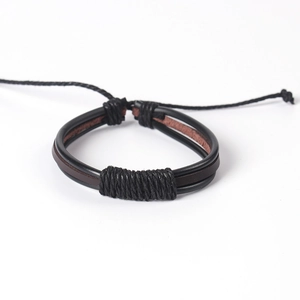 Détail de bracelets multicouches en cuir tressé main avec fermeture par cordon coulissant